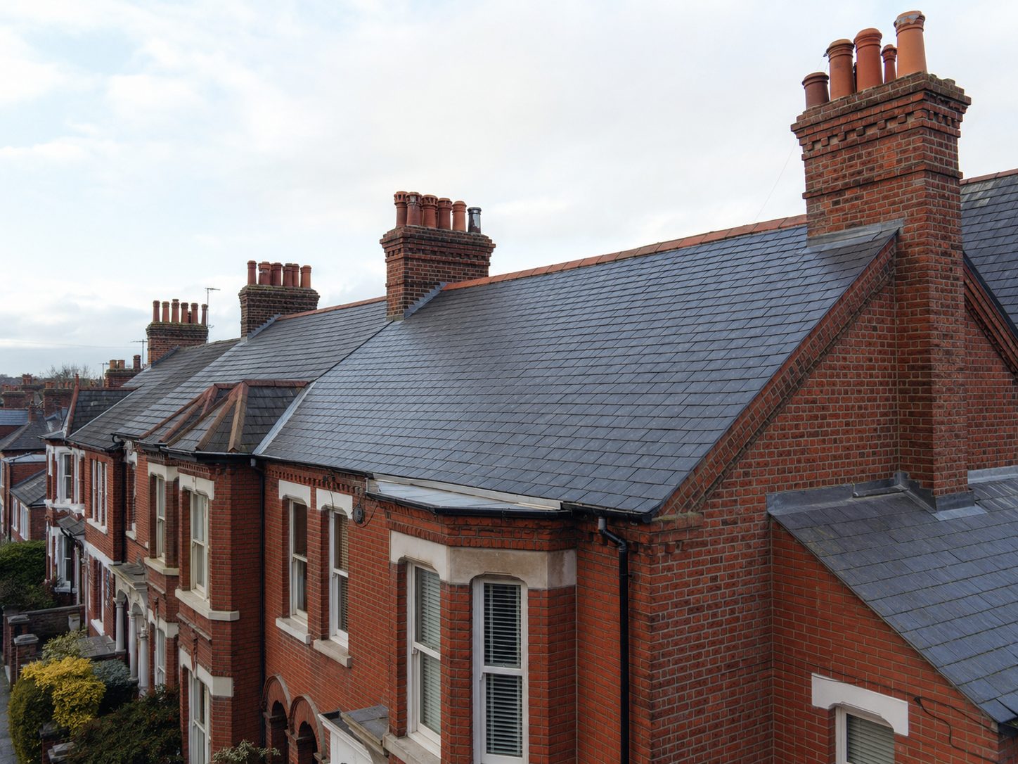 Natural slate roof on a Victorian terrace with brick chimneys